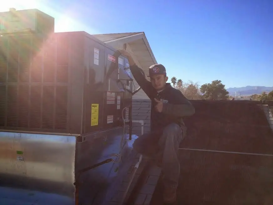 HVAC technician performing HVAC Inspection on a rooftop unit in Ballston